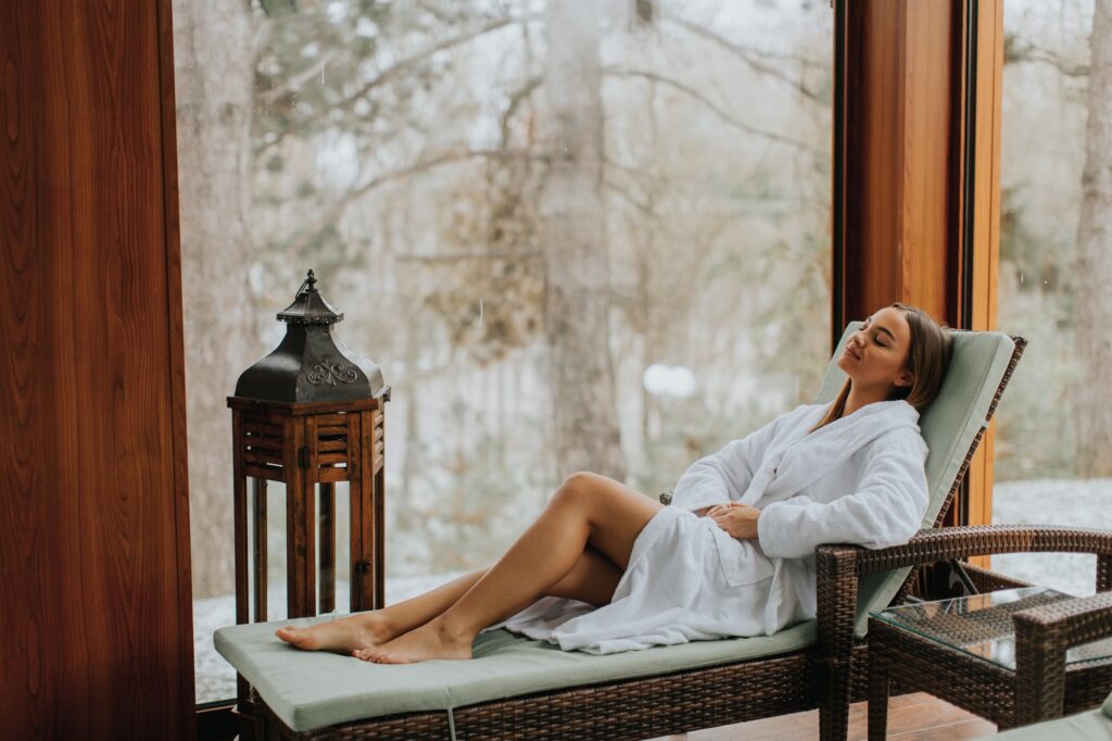 Pretty young woman relaxing by the indoor swimming pool at winter
